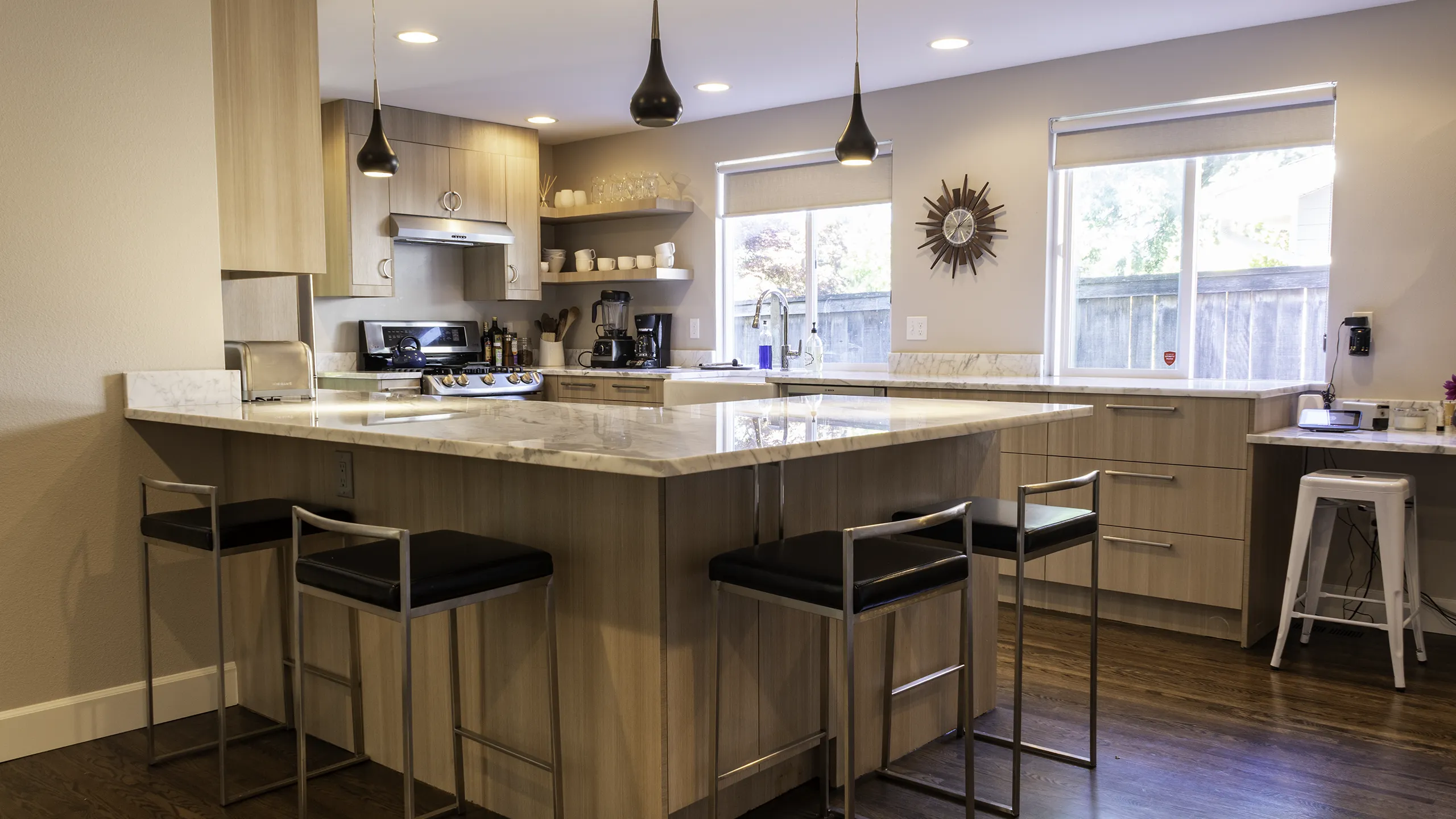 Completed Bellevue kitchen remodel — modern cabinets, marble countertops, pendant lighting, and hardwood floors