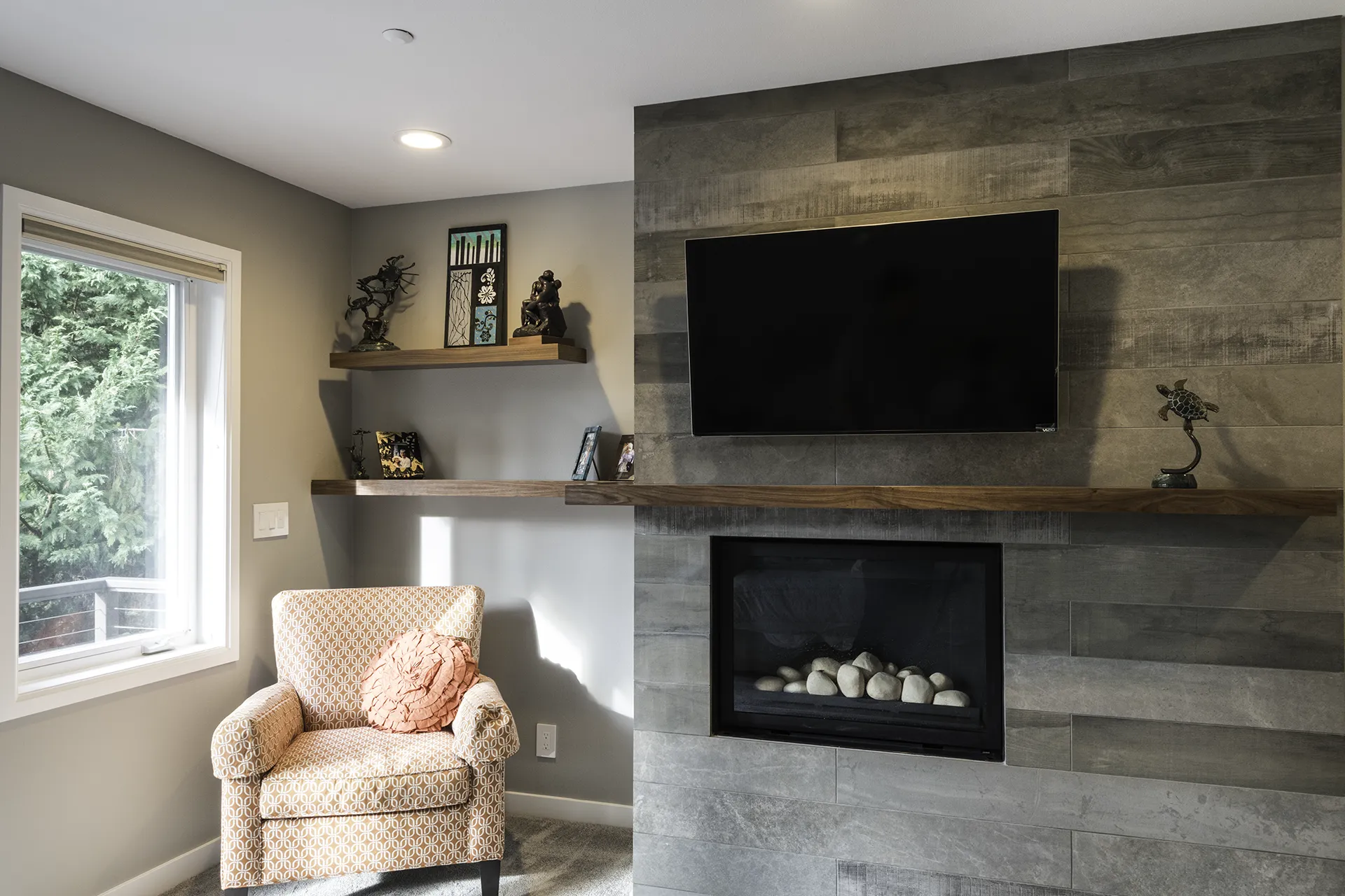 Custom fireplace surround with porcelain plank tile, live-edge wood mantel, and wraparound floating shelves — Issaquah home remodel