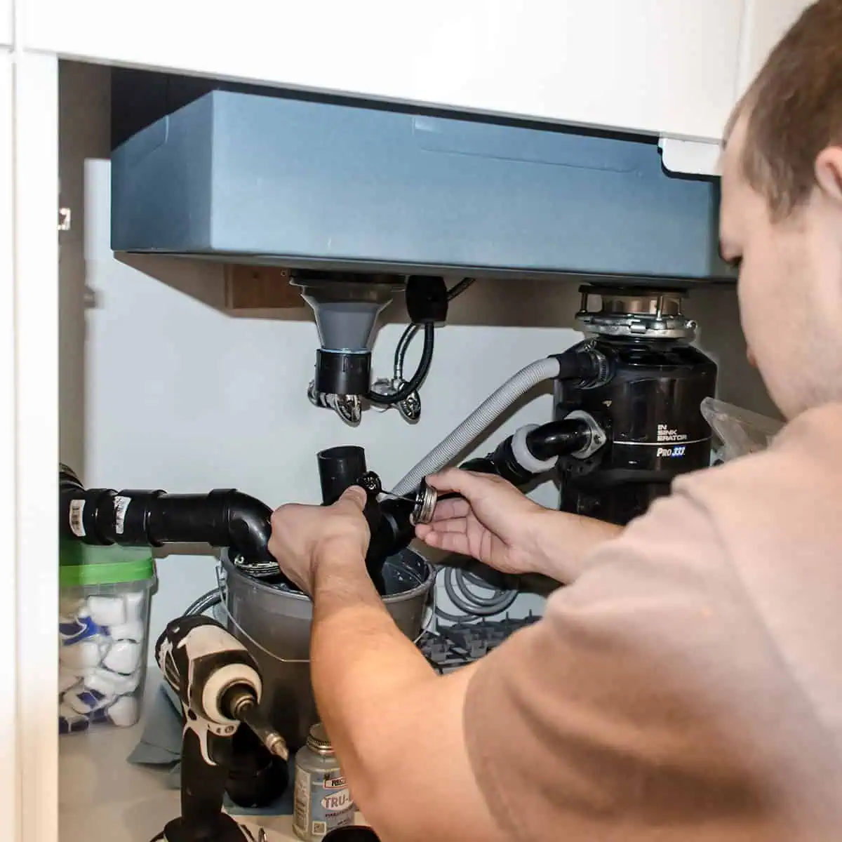 Plumber installing kitchen sink during NW Homeworks remodel