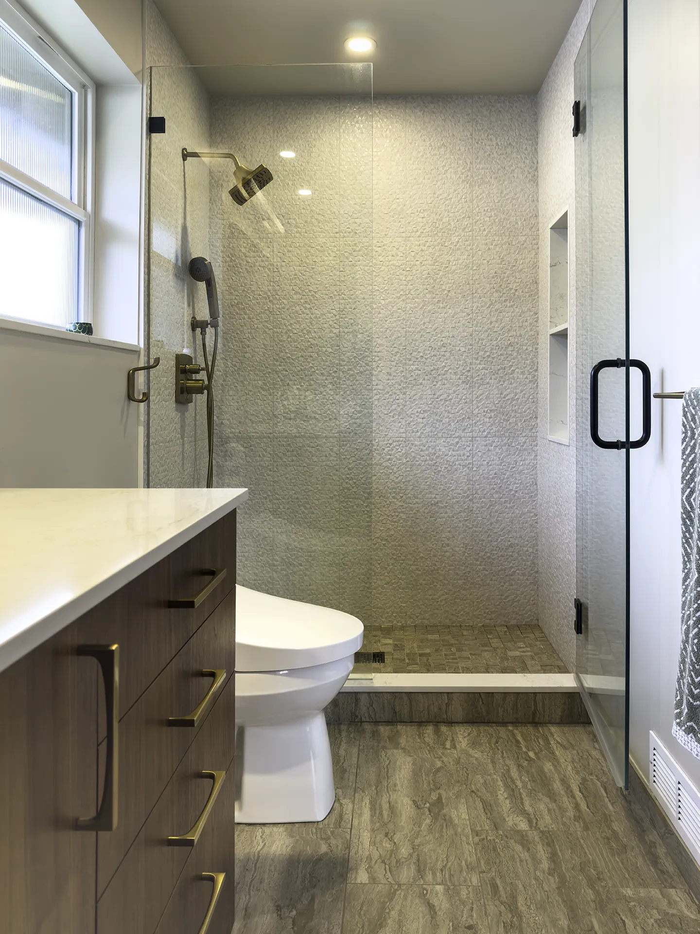 Normandy Park bathroom remodel with stone tile shower, brass fixtures, and walnut vanity