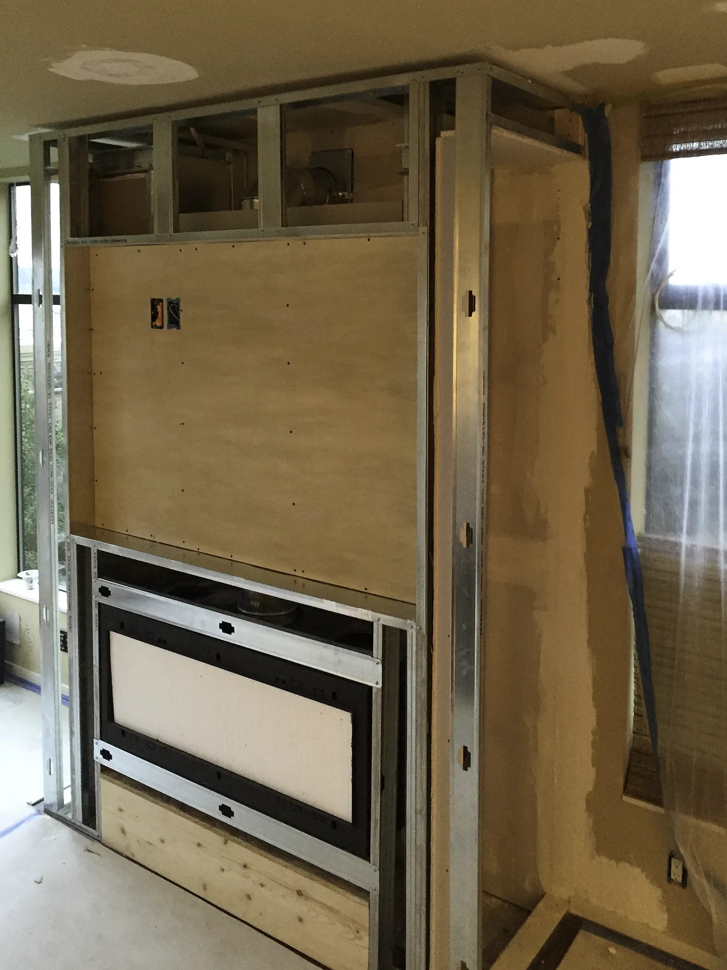 Queen Anne fireplace feature wall before — steel framing and fireplace insert during construction