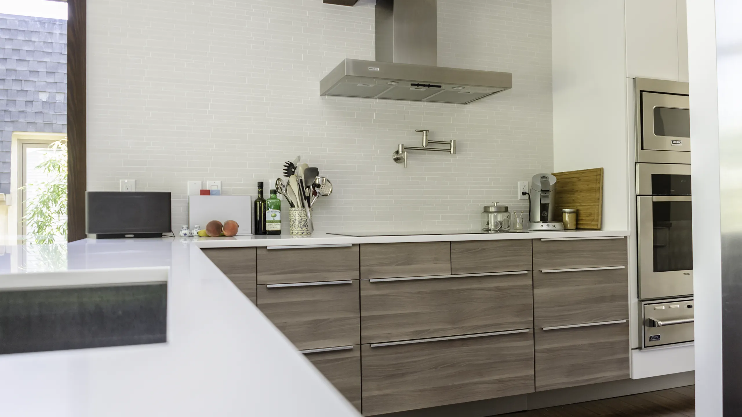 Kirkland IKEA kitchen installation — pot filler faucet, SOFIELUND cabinets, white tile backsplash, and built-in wall ovens