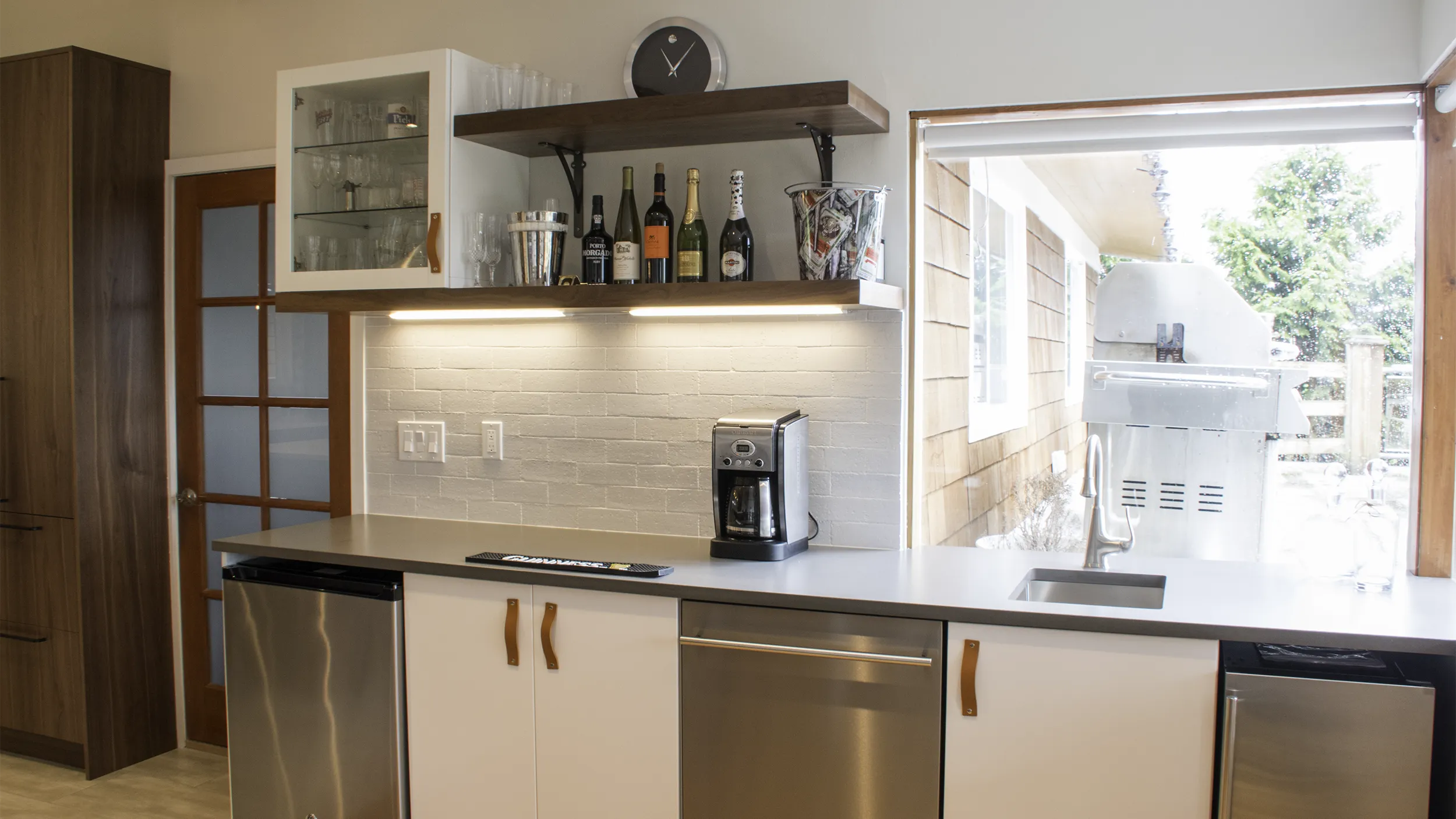 Custom mini bar and beverage center with floating walnut shelves and wine fridge by NW Homeworks
