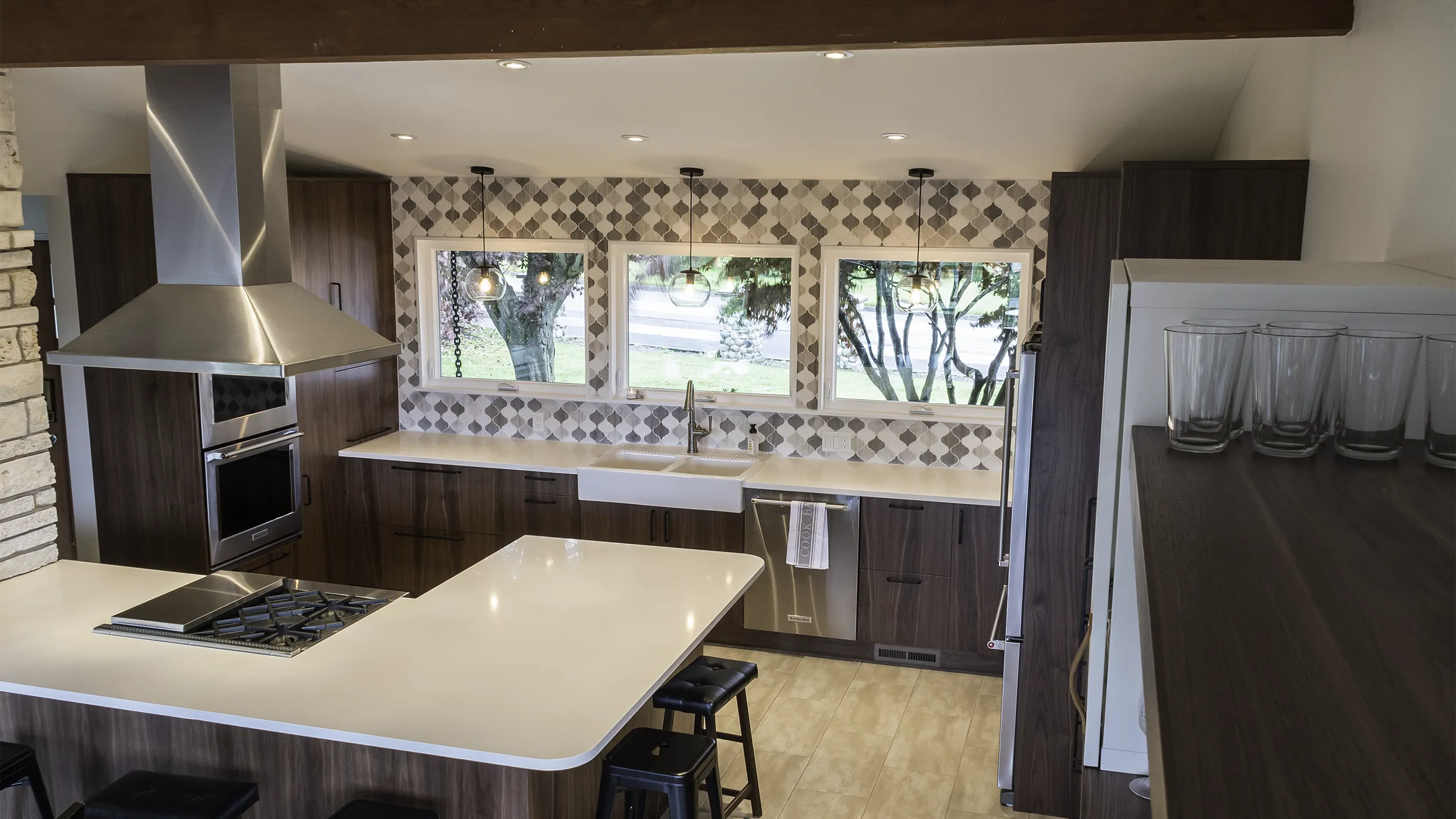 Mid-century kitchen remodel with white quartz peninsula, canopy hood, and farmhouse sink by NW Homeworks