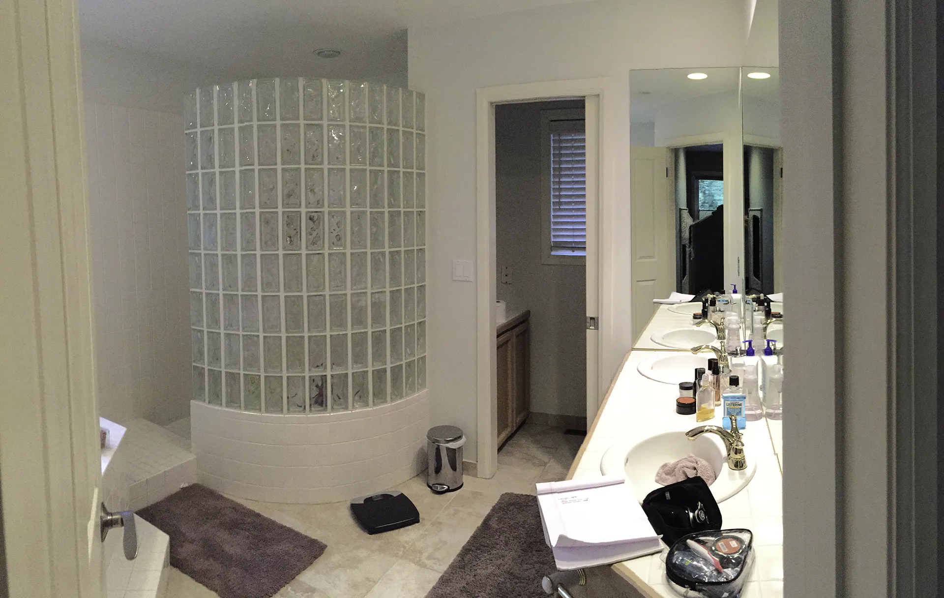 Primary bathroom before remodel with curved glass-brick shower enclosure