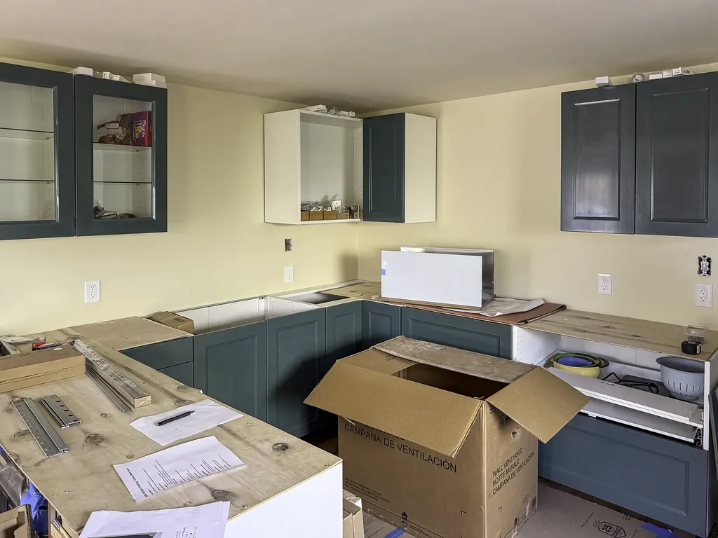 IKEA kitchen remodel in progress with the green Sektion cabinet boxes being set