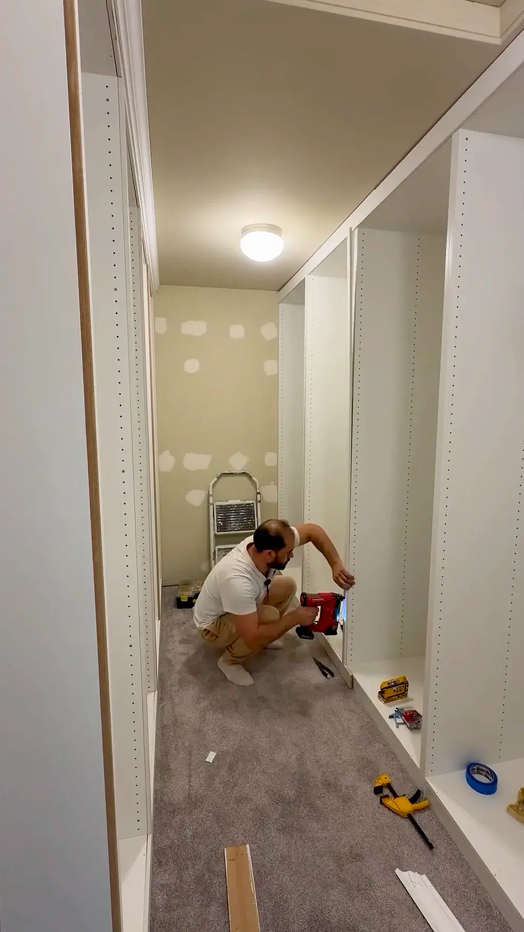 Built-in closet under construction with trim and filler strips being fitted between cabinets