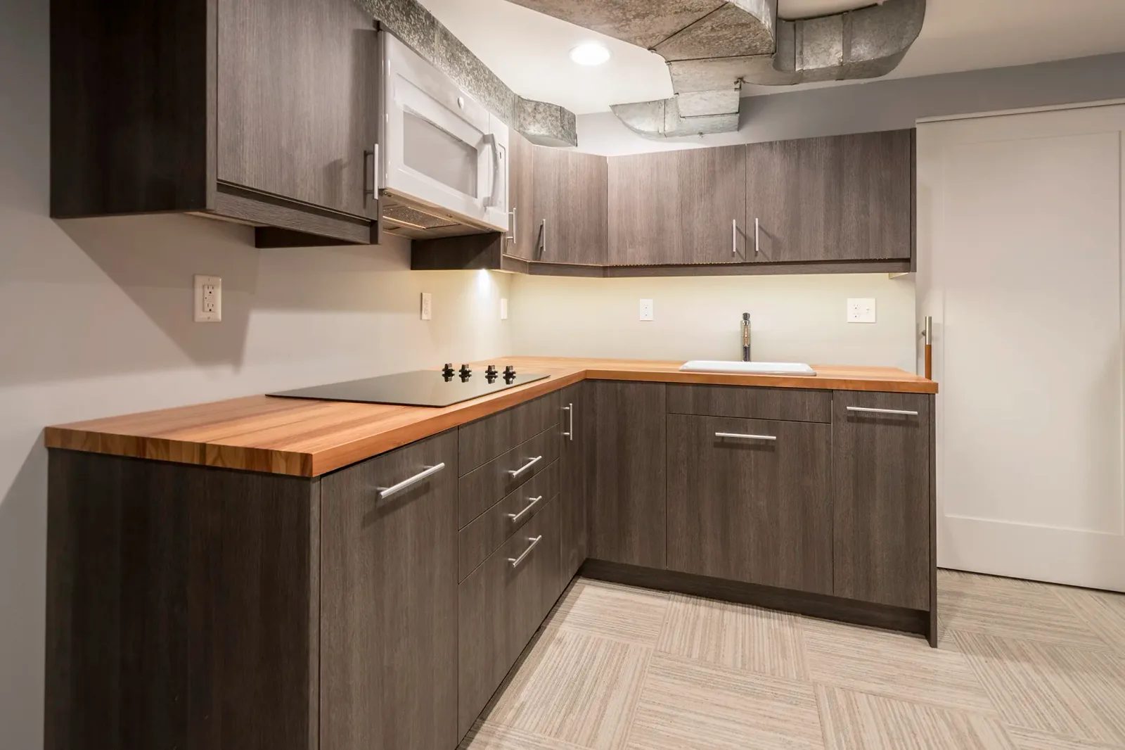 Basement kitchen remodel in NE Seattle with an induction cooktop and butcher block counter
