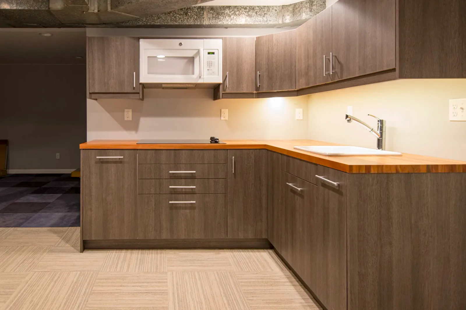 NE Seattle basement kitchenette with gray woodgrain cabinets and butcher block countertops