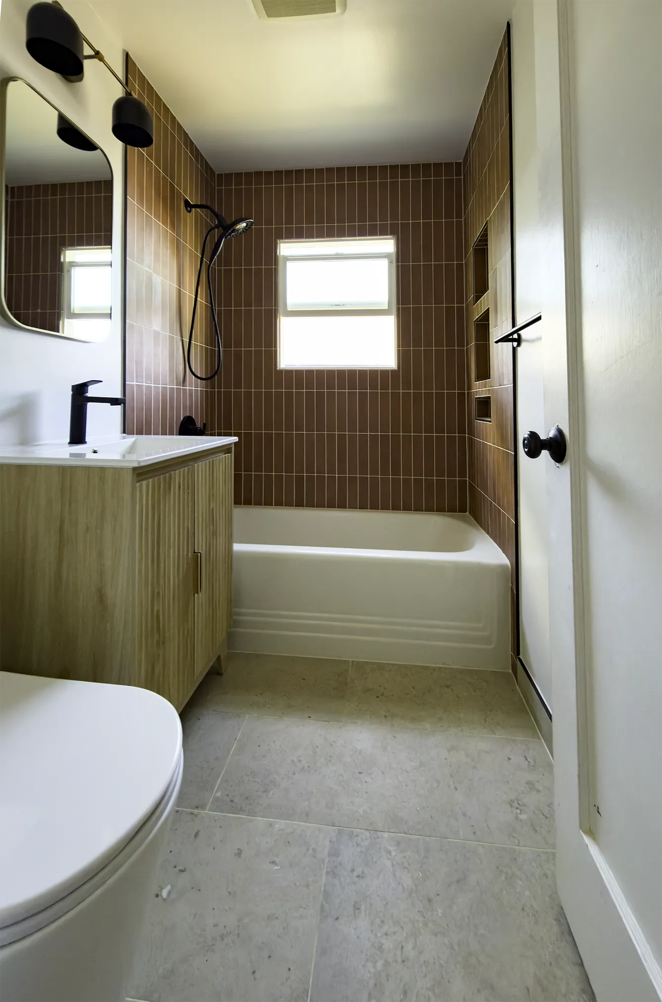 West Seattle bathroom remodel with stacked terracotta tile, black fixtures, and a fluted oak vanity