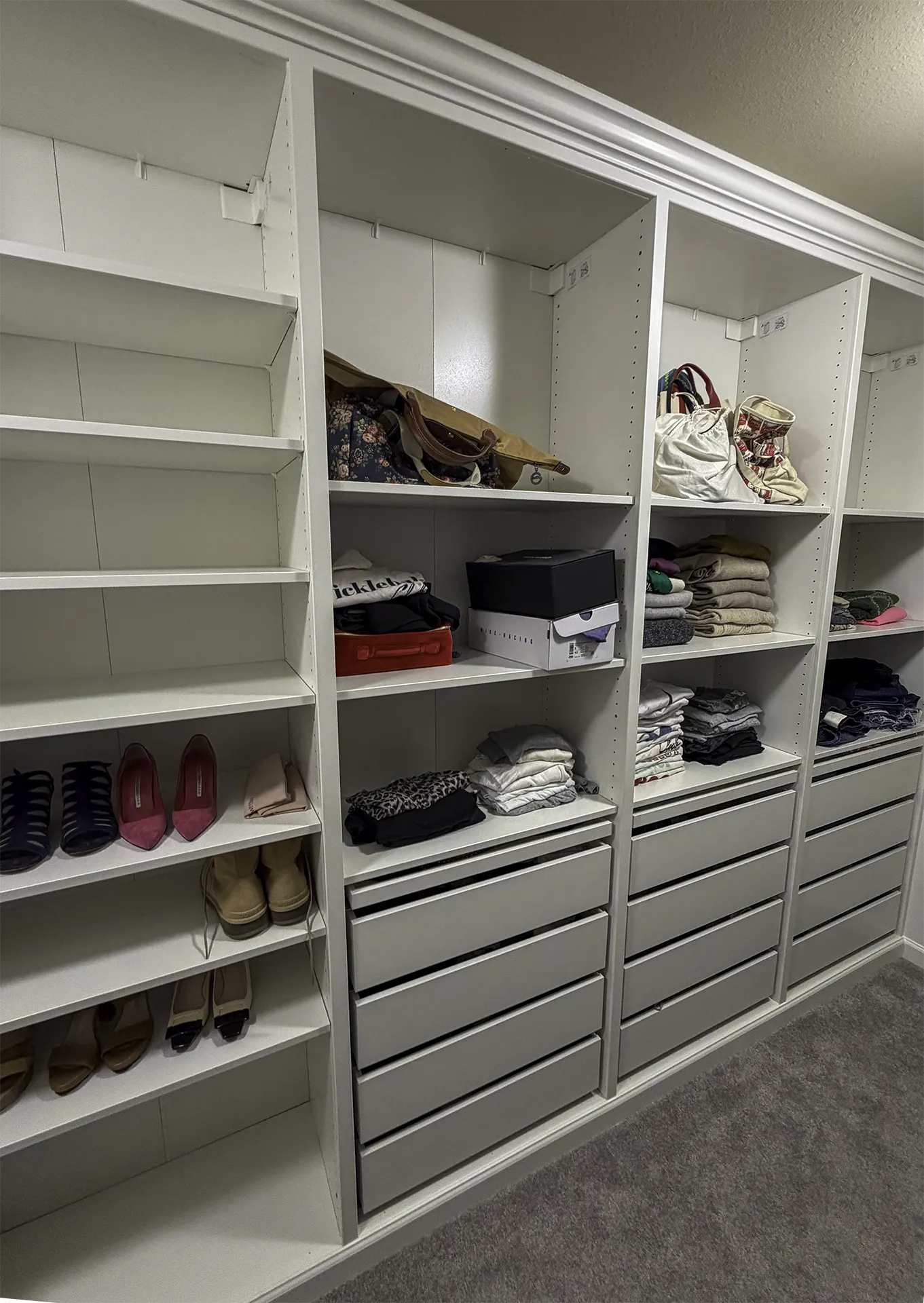 Close-up of organized IKEA PAX closet with shoe storage, drawers, and shelving