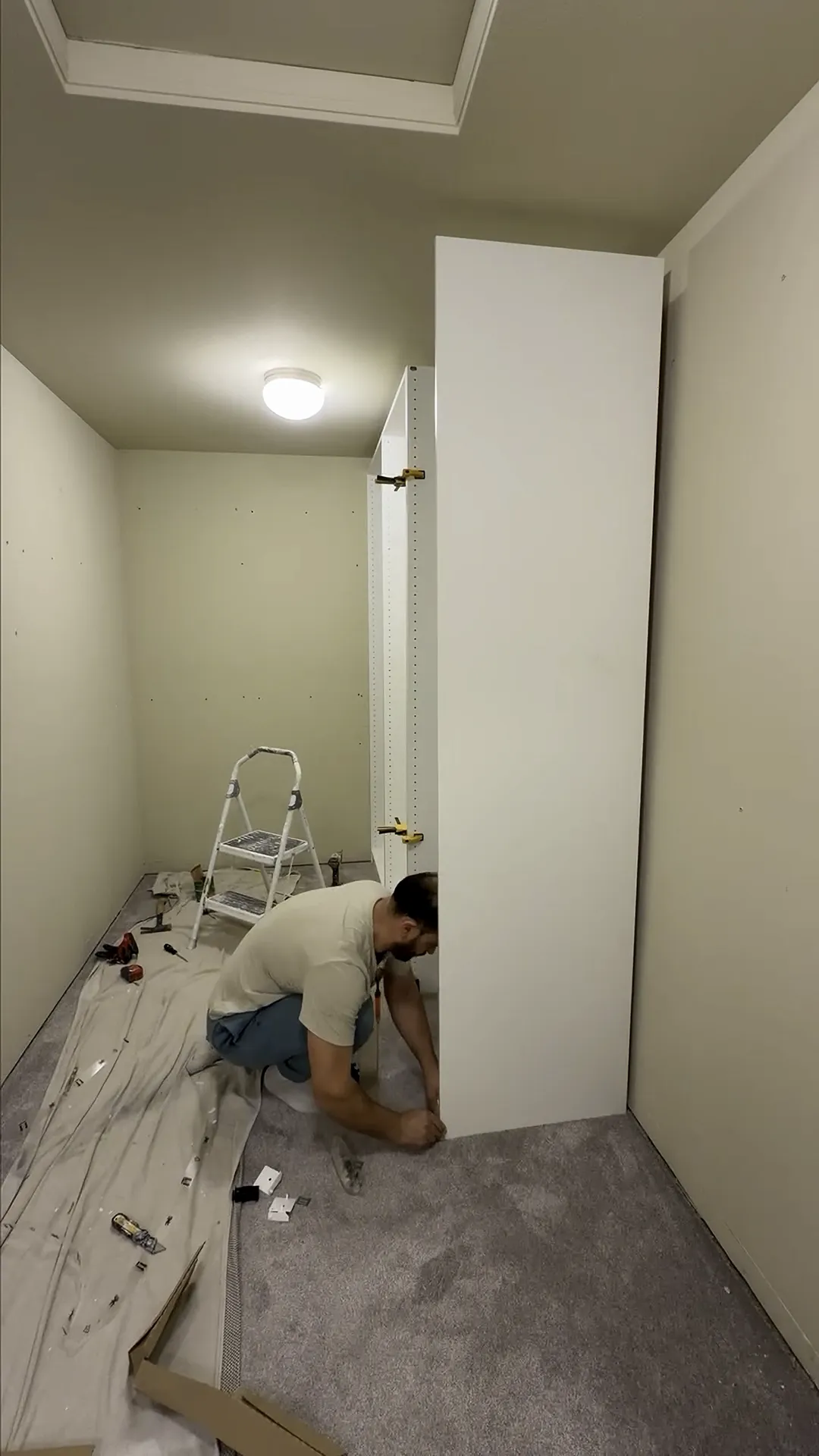 IKEA PAX wardrobe unit being assembled and installed in walk-in closet