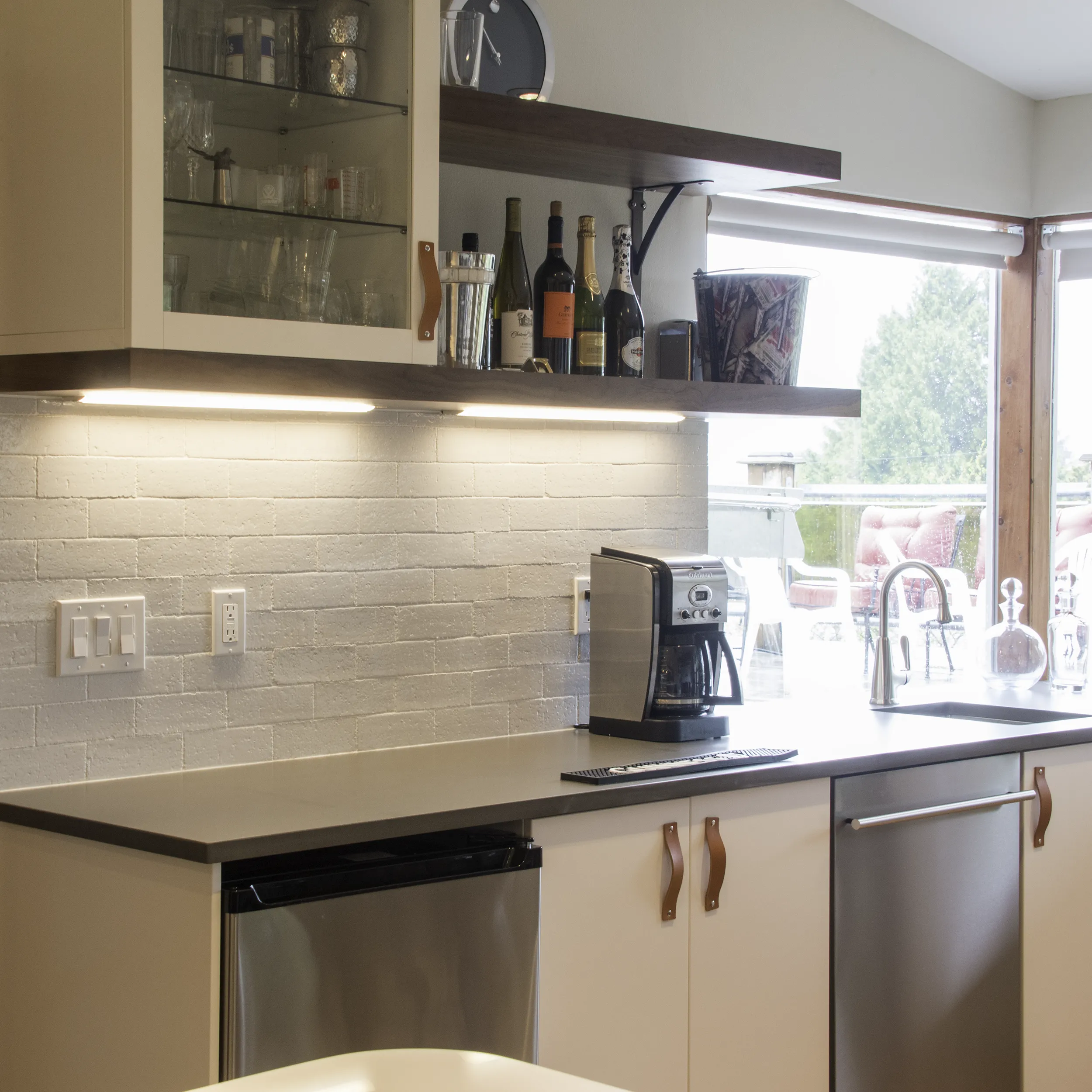 IKEA-based wet bar installation in a Normandy Park basement with floating shelves, wine display, beverage fridge, and espresso station