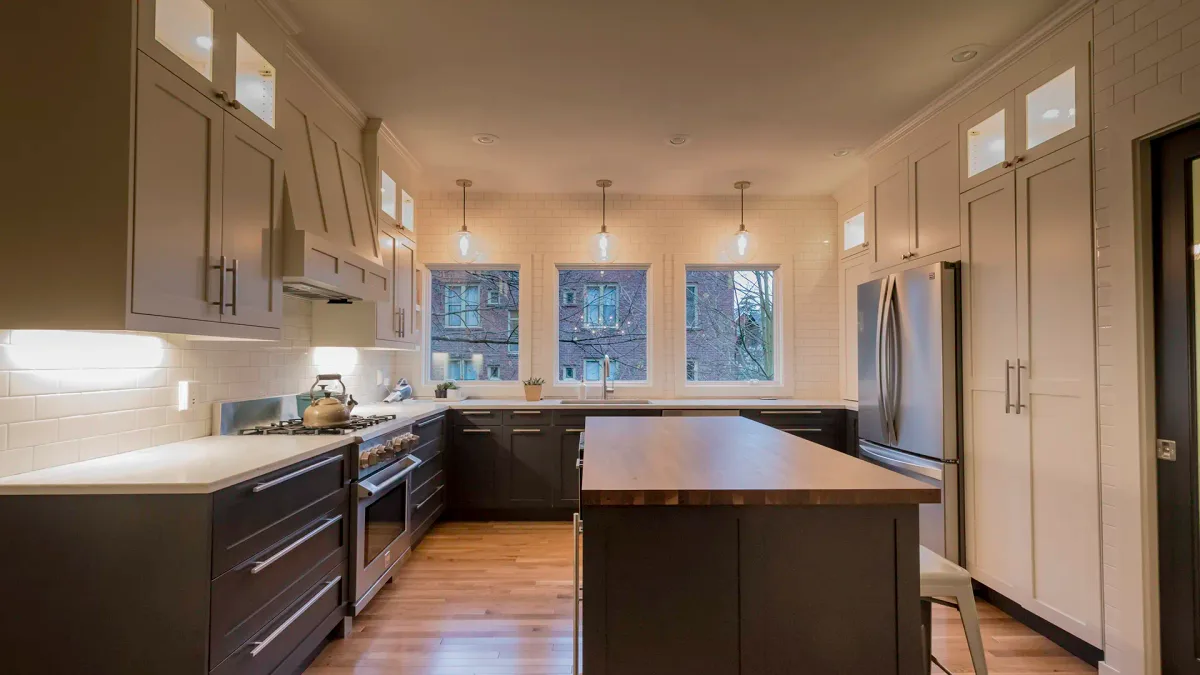 Evening shot of Seattle kitchen remodel showing pendant lights, recessed cans, and under-cabinet LED lighting