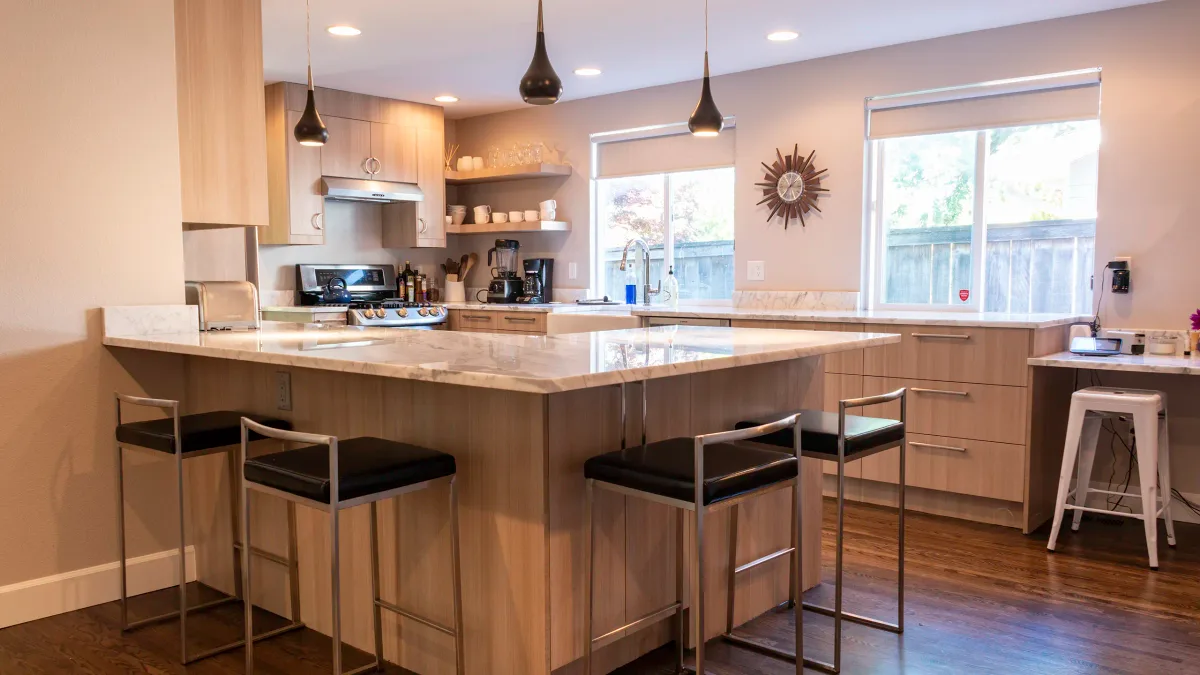 Upper-mid kitchen remodel in Bellevue with large island, stone countertops, and pendant lighting