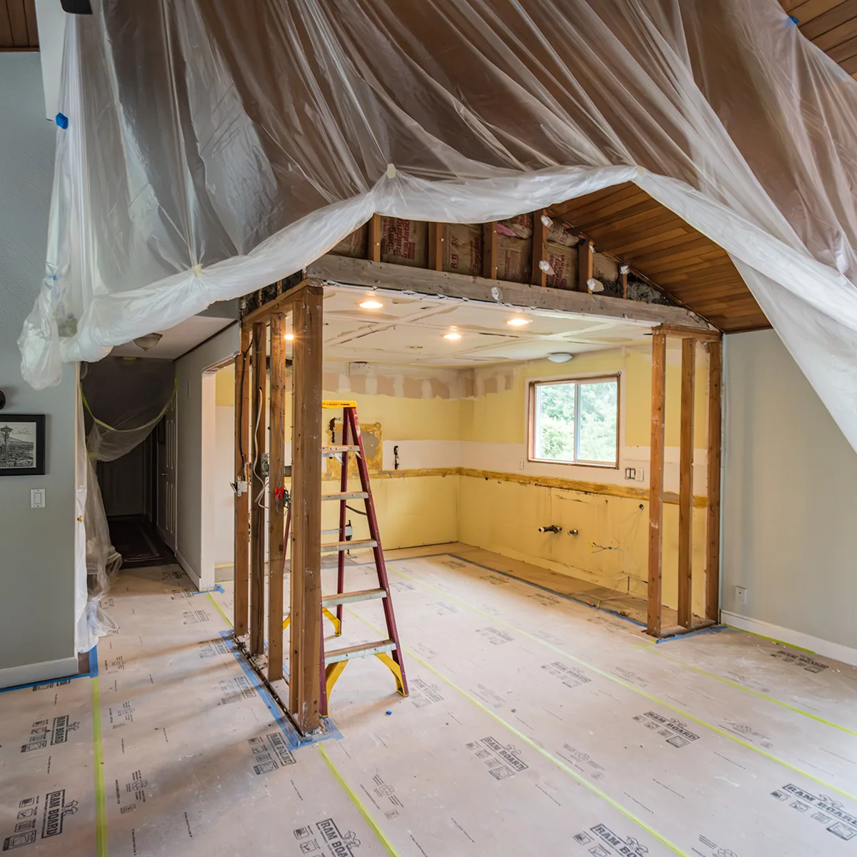 Kitchen remodel in progress showing exposed framing and dust control in Seattle home